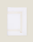 folded white linen table runner with beige stripes embroidery