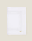 folded white linen table runner with white stripes embroidery