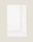 folded white tablecloth with beige stripes embroidery