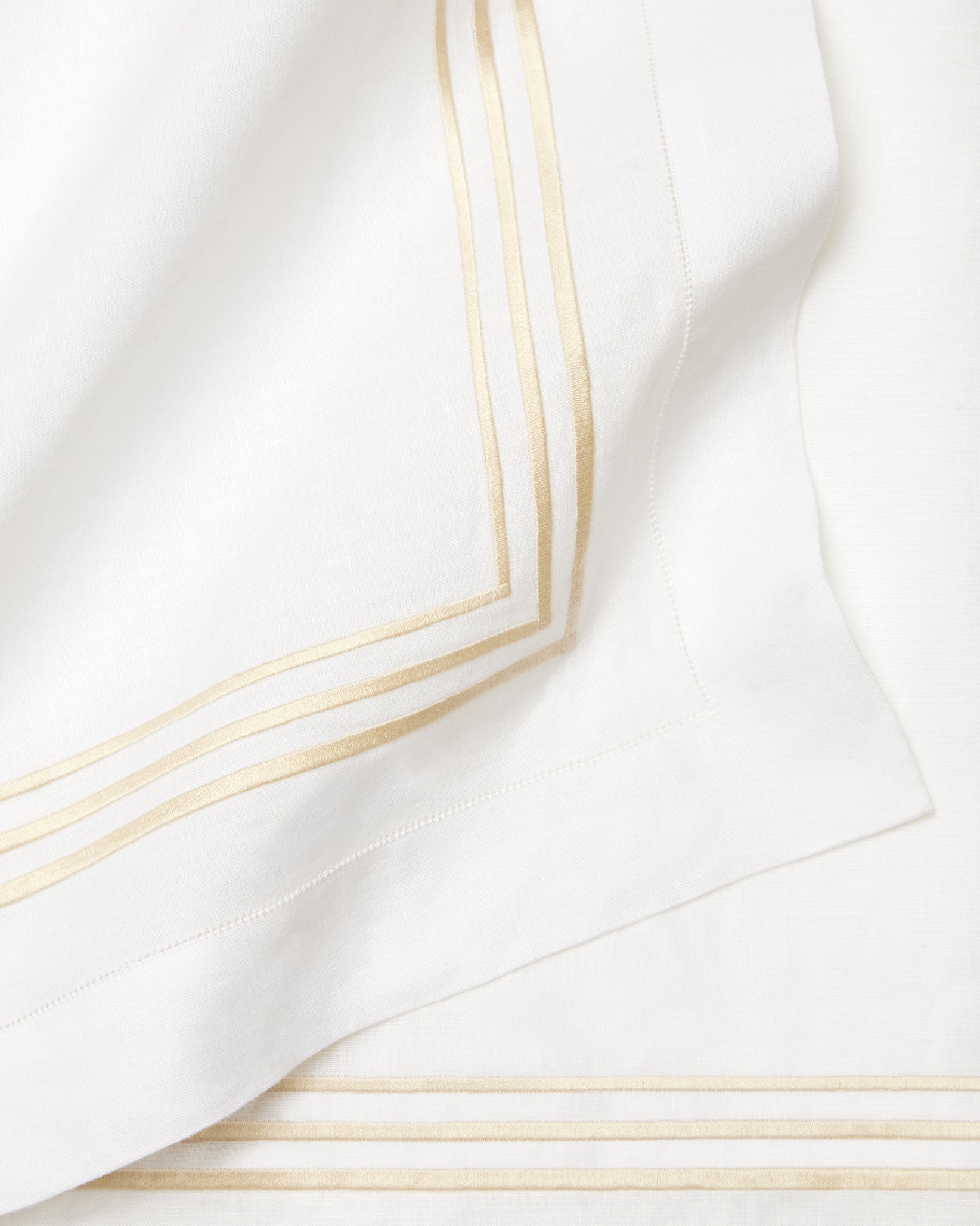 Close-up of a white fabric with beige stripes embroidery