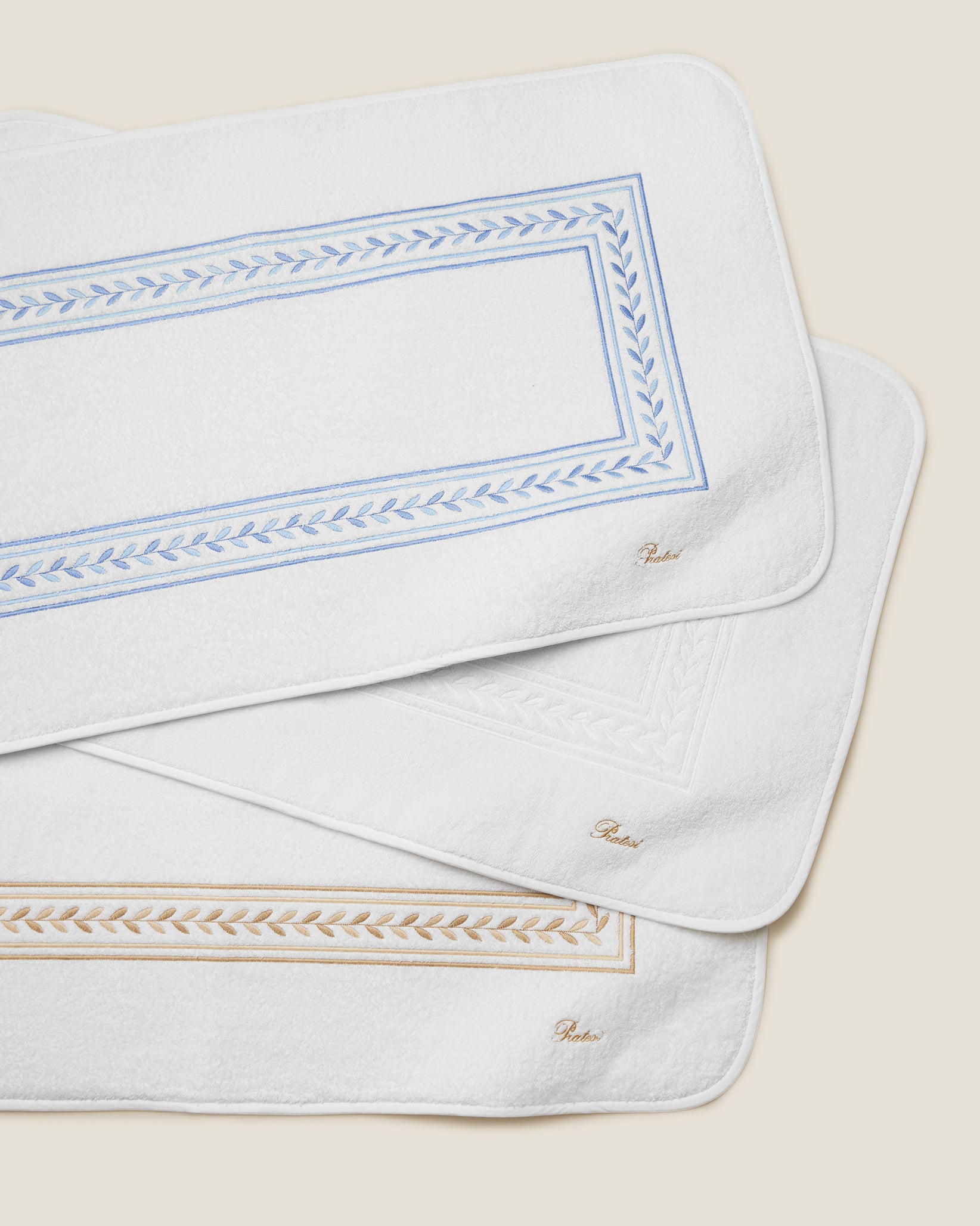 Impero Tub Mats stacked in white/medium blue, white/white, and white/beige