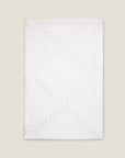 folded white tablecloth with braid motif pattern
