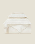 Impero Ivory duvet cover folded with the shams stacked above it.