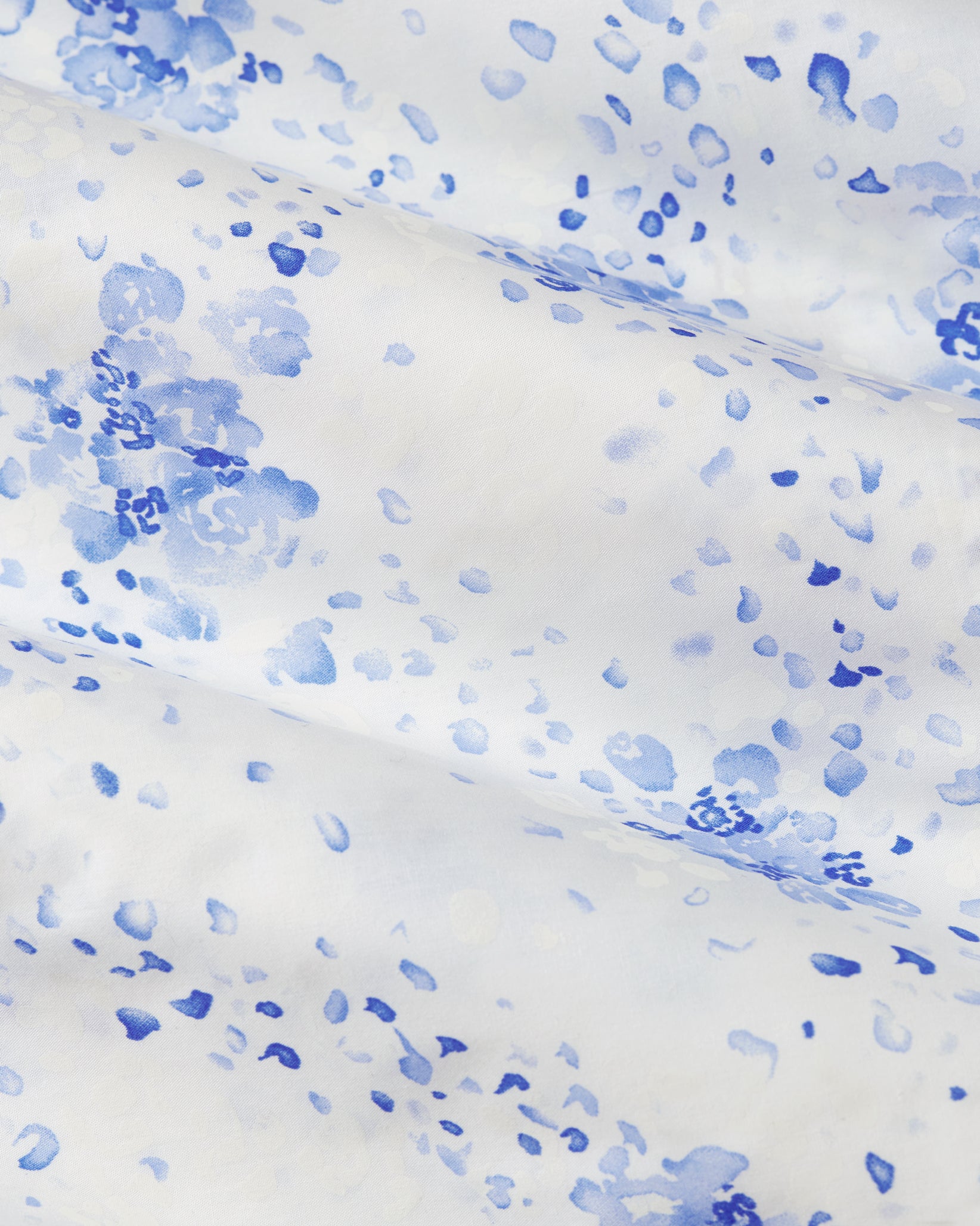 White fabric with blue watercolor-like speckles