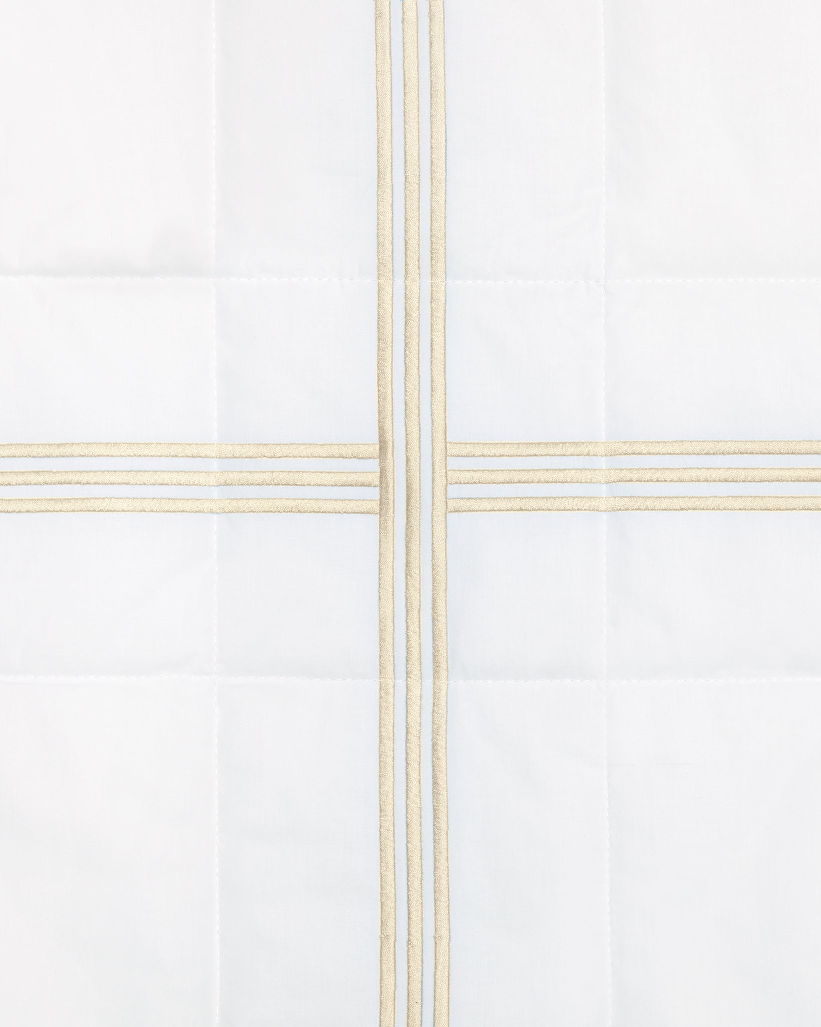 swatch of a white quiltino with beige embroidery