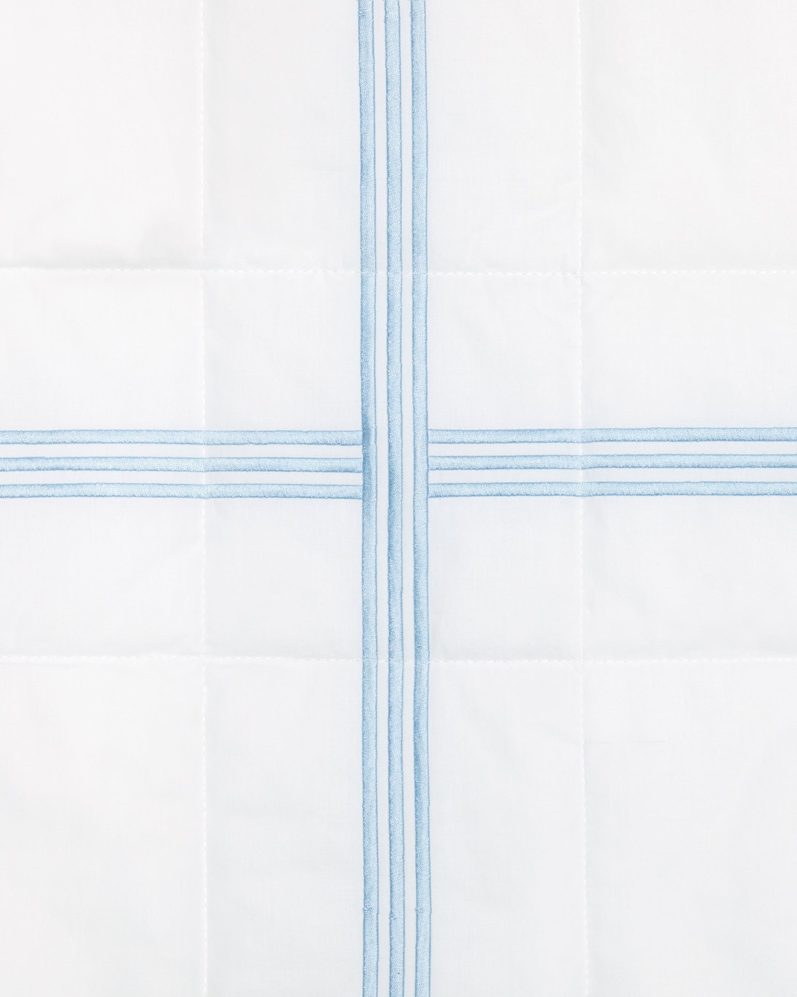 swatch of a white quiltino with light blue embroidery