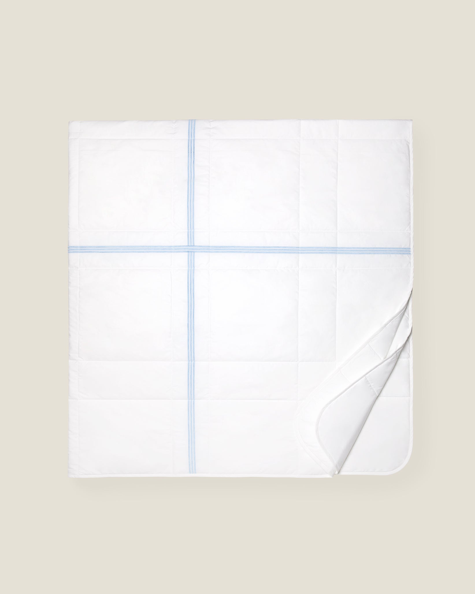 white quiltino with light blue embroidery