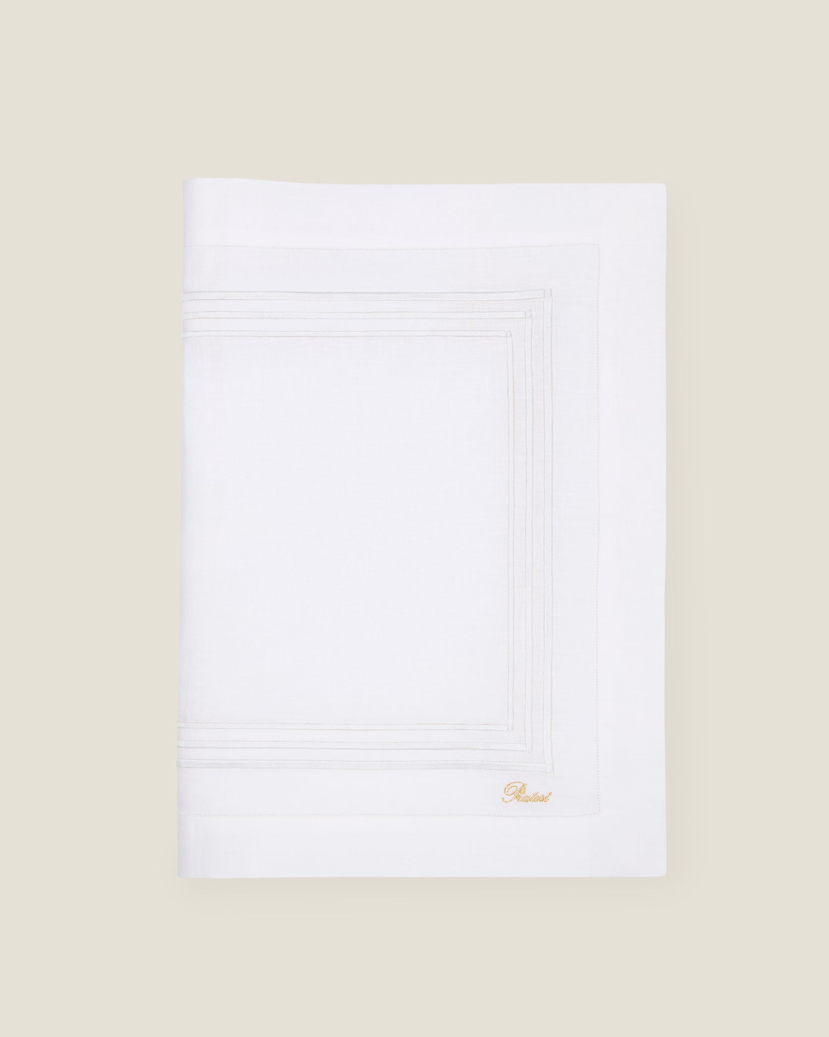 folded white linen table runner with white stripes embroidery