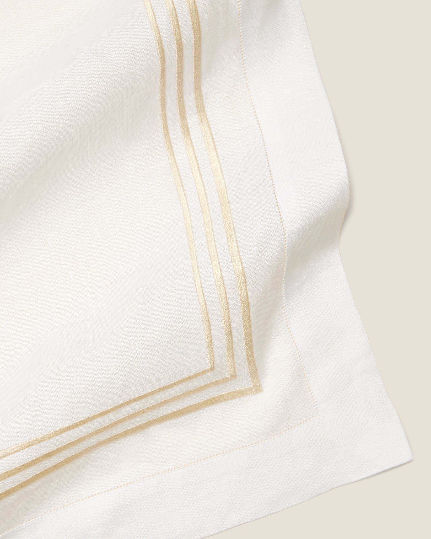 close up white linen table runner with beige embroidery