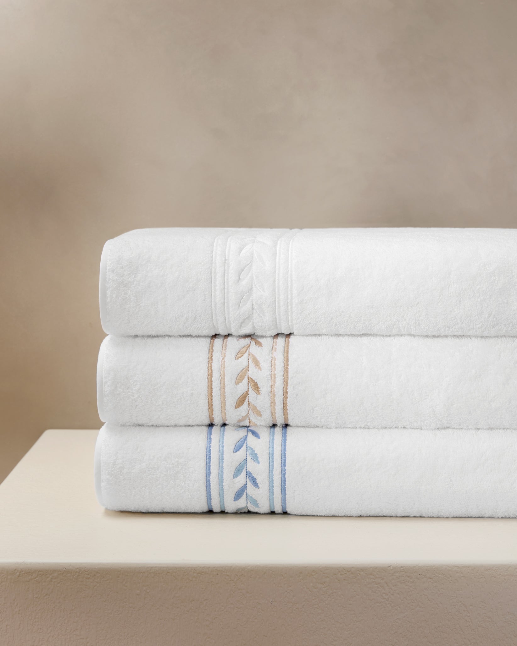 Impero Towels stacked in white/white, white/beige, white/medium blue