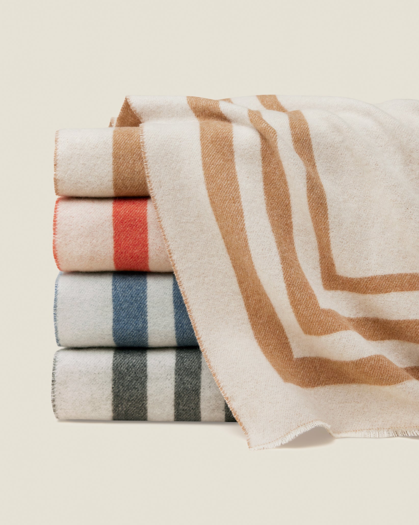 Tre Righe Throw in beige, orange, medium blue, and charcoal stacked