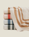 Tre Righe Throw in beige, orange, medium blue, and charcoal stacked