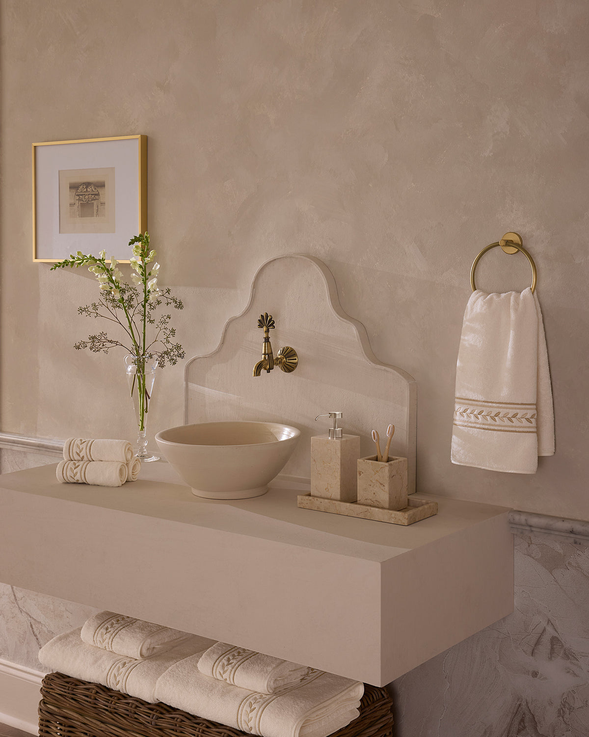 Impero ivory/beige bath towels folded on and under sink.